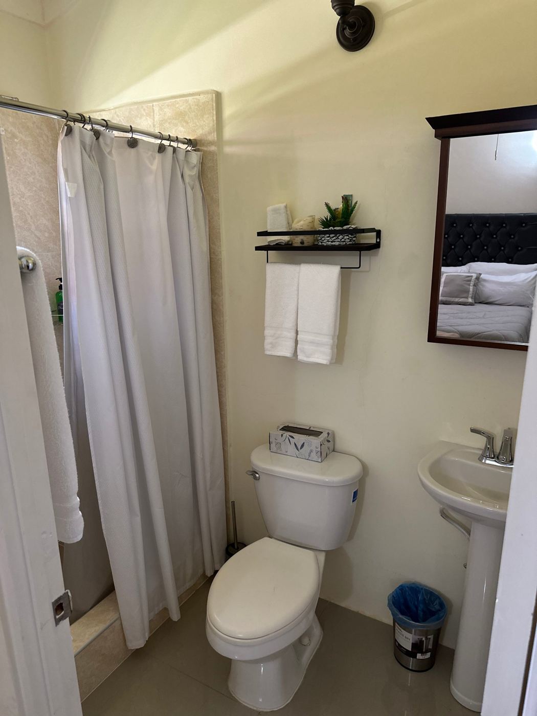 Bathroom with a walk-in shower, pedestal sink and fresh towels