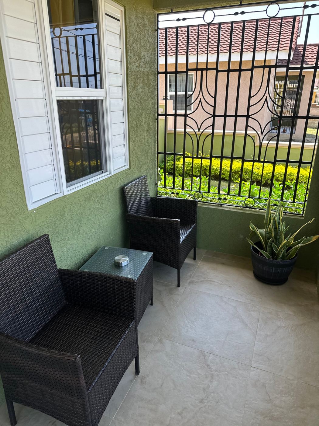 Covered patio with two wicker chairs and a side table